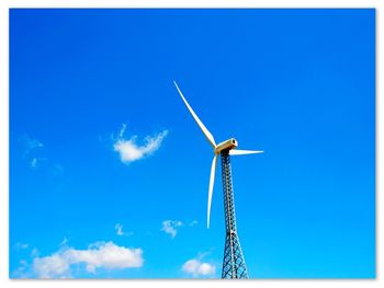 Low angle view of wind turbine against blue sky