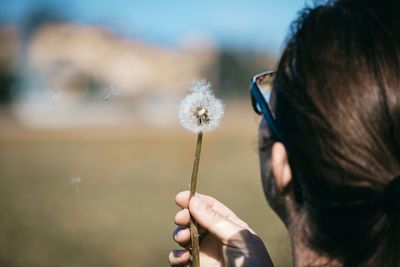 Close-up of woman holding dandelion flower