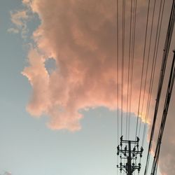 Low angle view of silhouette electricity pylon against sky