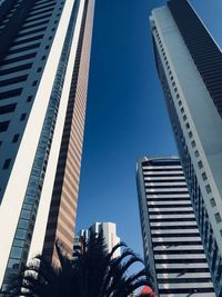 Low angle view of modern buildings against clear blue sky