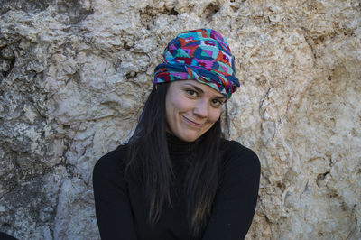 Portrait of smiling woman against rock