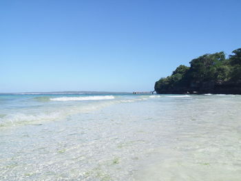 Scenic view of beach against clear blue sky