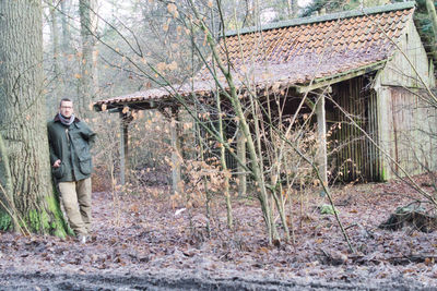 Man standing by tree in forest