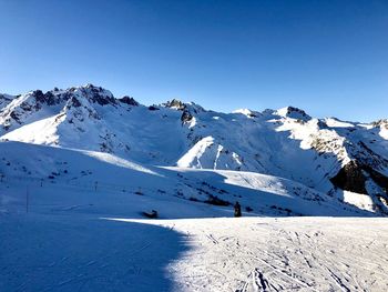 Scenic view of snowcapped mountains against clear blue sky