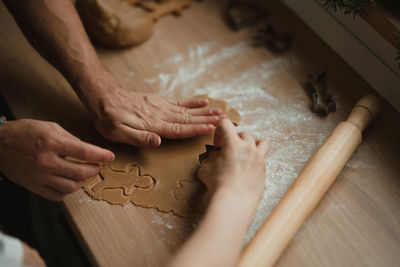 High angle view of man hands making gingerbread from dough