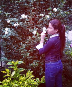 Woman standing on rock by plants