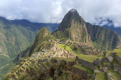 Scenic view of mountain range against cloudy sky