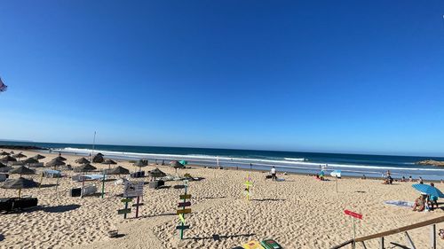 Scenic view of beach against clear blue sky