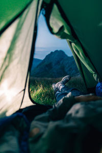 Low section of man relaxing in tent