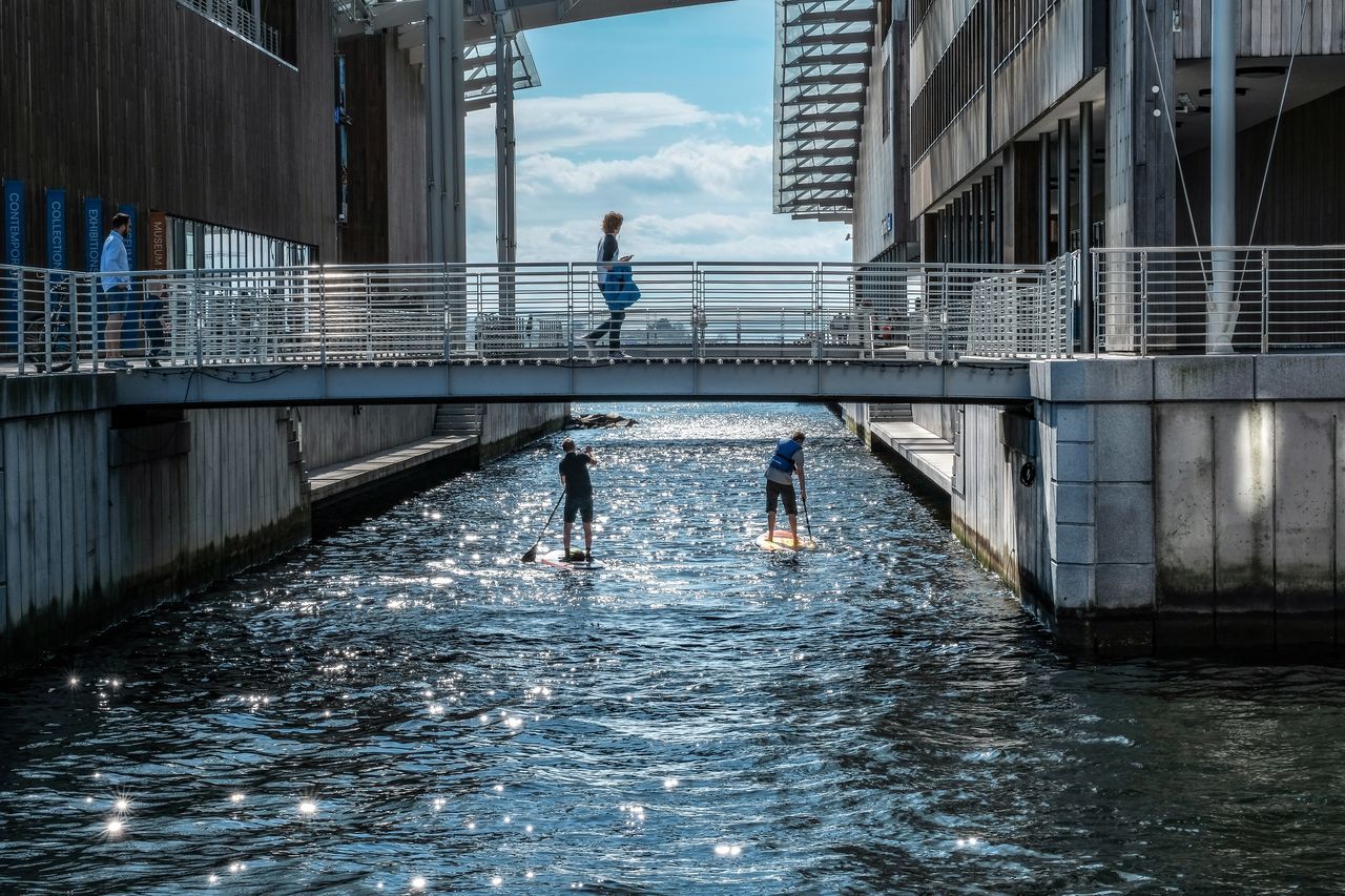 architecture, built structure, water, building exterior, waterfront, nature, real people, men, day, lifestyles, two people, city, people, motion, bridge, leisure activity, outdoors, connection, river