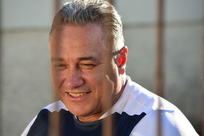 Close-up of smiling man seen through metal