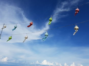 Low angle view of decoration hanging against blue sky