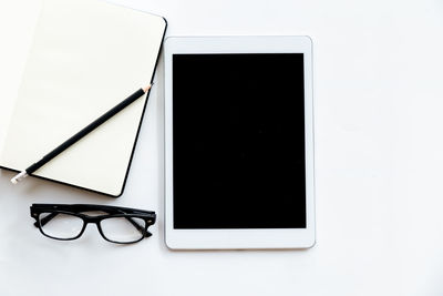 Close-up of eyeglasses on table against white background