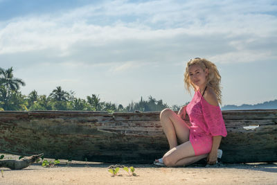 Portrait of beautiful young woman against sky