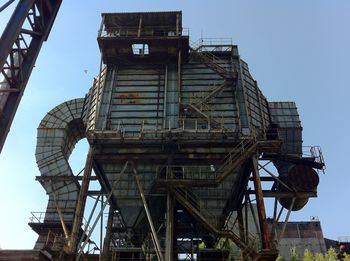 Low angle view of rusty steel mill structure against sky