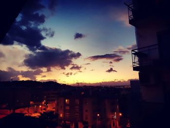 Silhouette buildings against sky at sunset