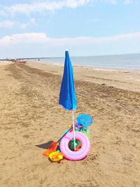 Toy on beach against sky