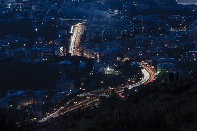 High angle view of illuminated street amidst buildings in city