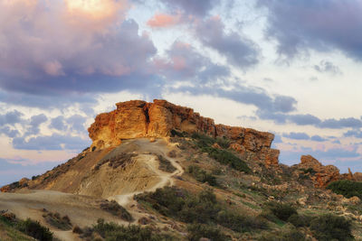 Low angle view of fort on mountain against cloudy sky