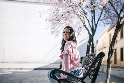 Portrait of young woman against trees