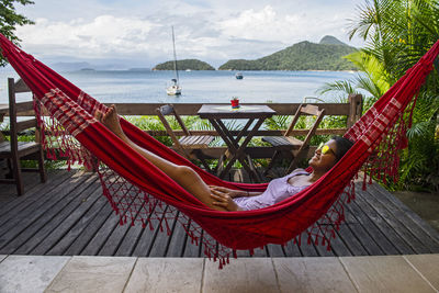 Woman relaxing in hammock on the tropical island og ilha grande