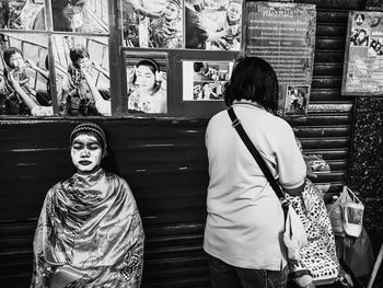 Rear view of woman standing against graffiti