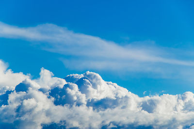 White fluffy cumulus clouds against a clear blue sky. top view from the plane. 