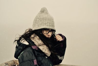 Portrait of young woman wearing knit hat during foggy weather
