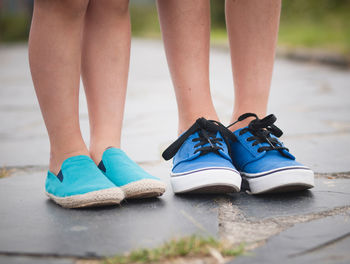 Low section of woman wearing shoes standing outdoors