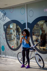 Full length of woman with bicycle standing on glass