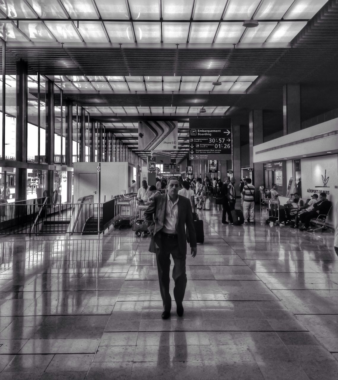 indoors, men, lifestyles, person, ceiling, walking, full length, architecture, built structure, flooring, illuminated, tiled floor, city life, public transportation, railroad station, leisure activity, passenger, transportation