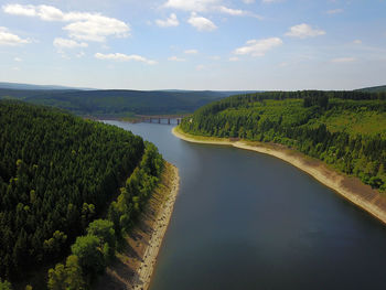 High angle view of river amidst trees against sky