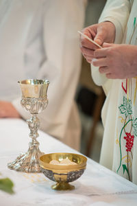 Midsection of priest praying at altar in church