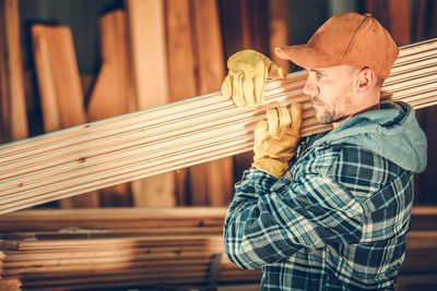 Man holding umbrella standing on wood