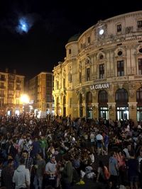 Group of people in front of historical building at night