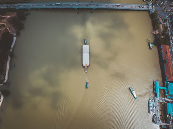 Aerial view of ships sailing in river at city