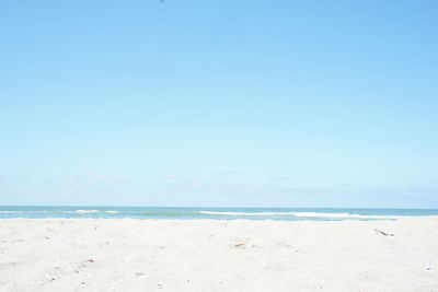 Scenic view of beach against blue sky