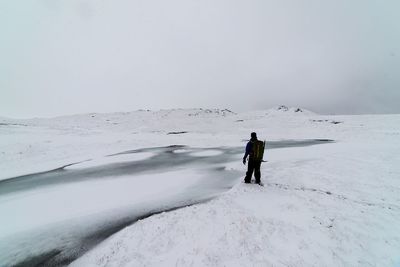 Full length of woman standing on snow covered landscape