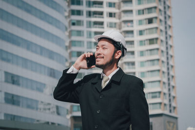 Young man using mobile phone in city