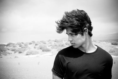 Close-up of man standing at beach against sky