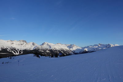 Scenic view of snowcapped mountains against blue sky