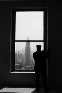 Rear view of policeman looking through window