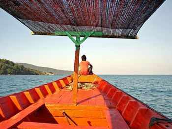 Boy sitting on bow of fishing boat cambodia 