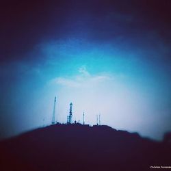 Low angle view of silhouette smoke stack against sky