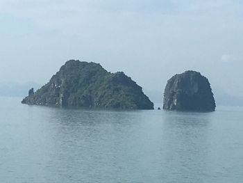 Scenic view of sea by cliff against sky