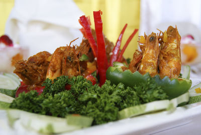Close-up of prawns garnish with sliced cucumber on table