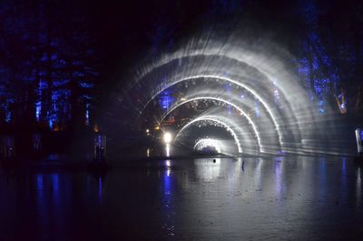 Illuminated bridge over river at night