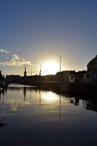 Reflection of built structures in water at sunset