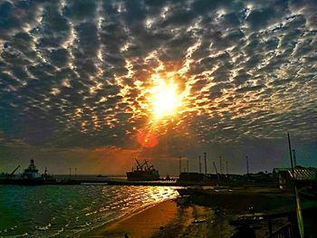 Scenic view of sea against cloudy sky at sunset