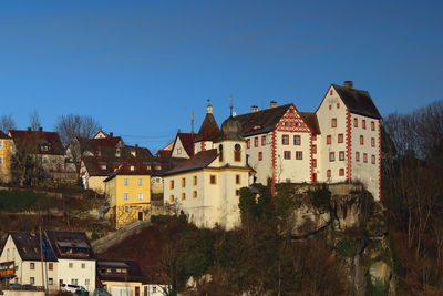 Buildings in city against clear blue sky